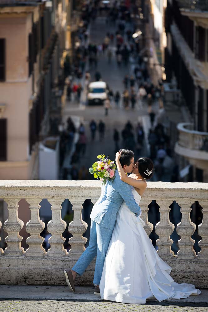 Romantic image of a wed couple close together by the marble balconade