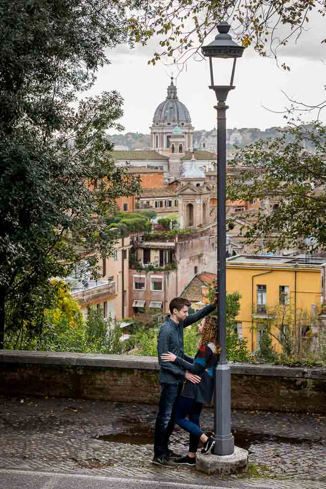 Posing by a street lamp with the beautiful roman scenery in the background