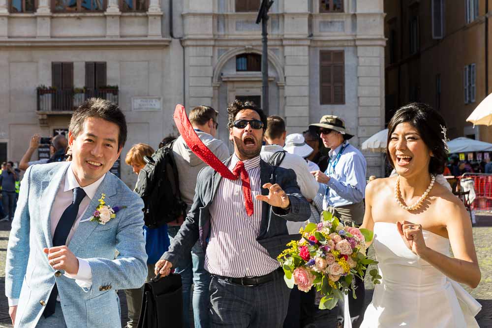 Funny wedding picture of bride and groom chased by a strange businessman