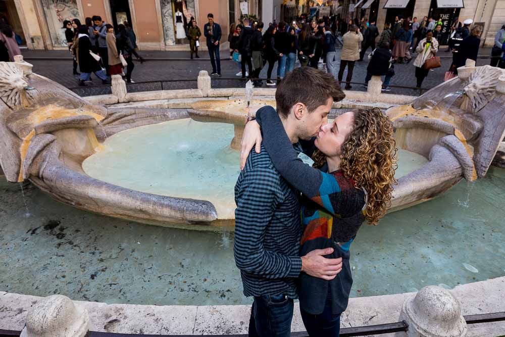 Kissing close together in front of the Barcaccia water fountain