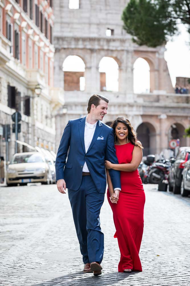 Walking hand in hand in the city of Rome with the Colosseum in the background