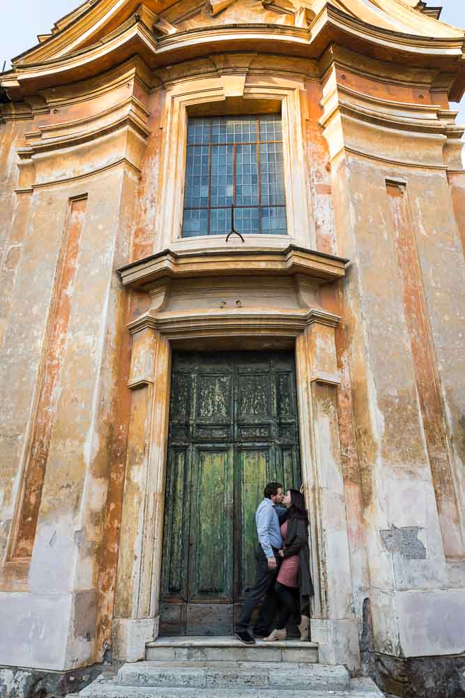 Romantic portrait picture in front of a green door underneath an old building