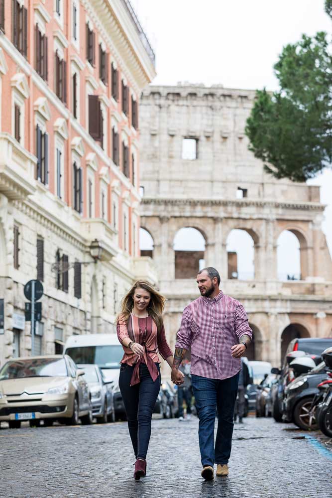 Walking together on a typical roman alleyway street with the Coliseum in the background