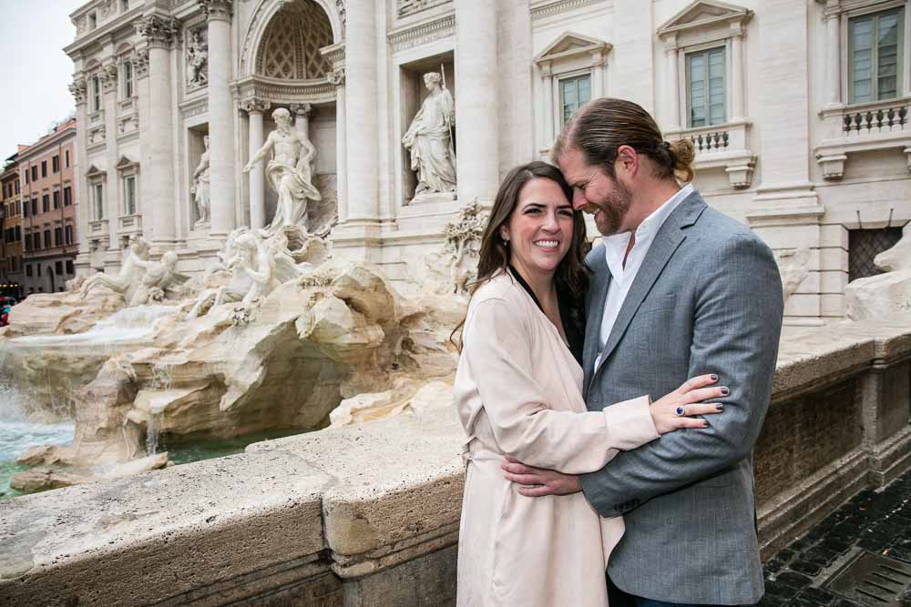 Couple posing in Rome's Trevi fountain during an engagement photo session