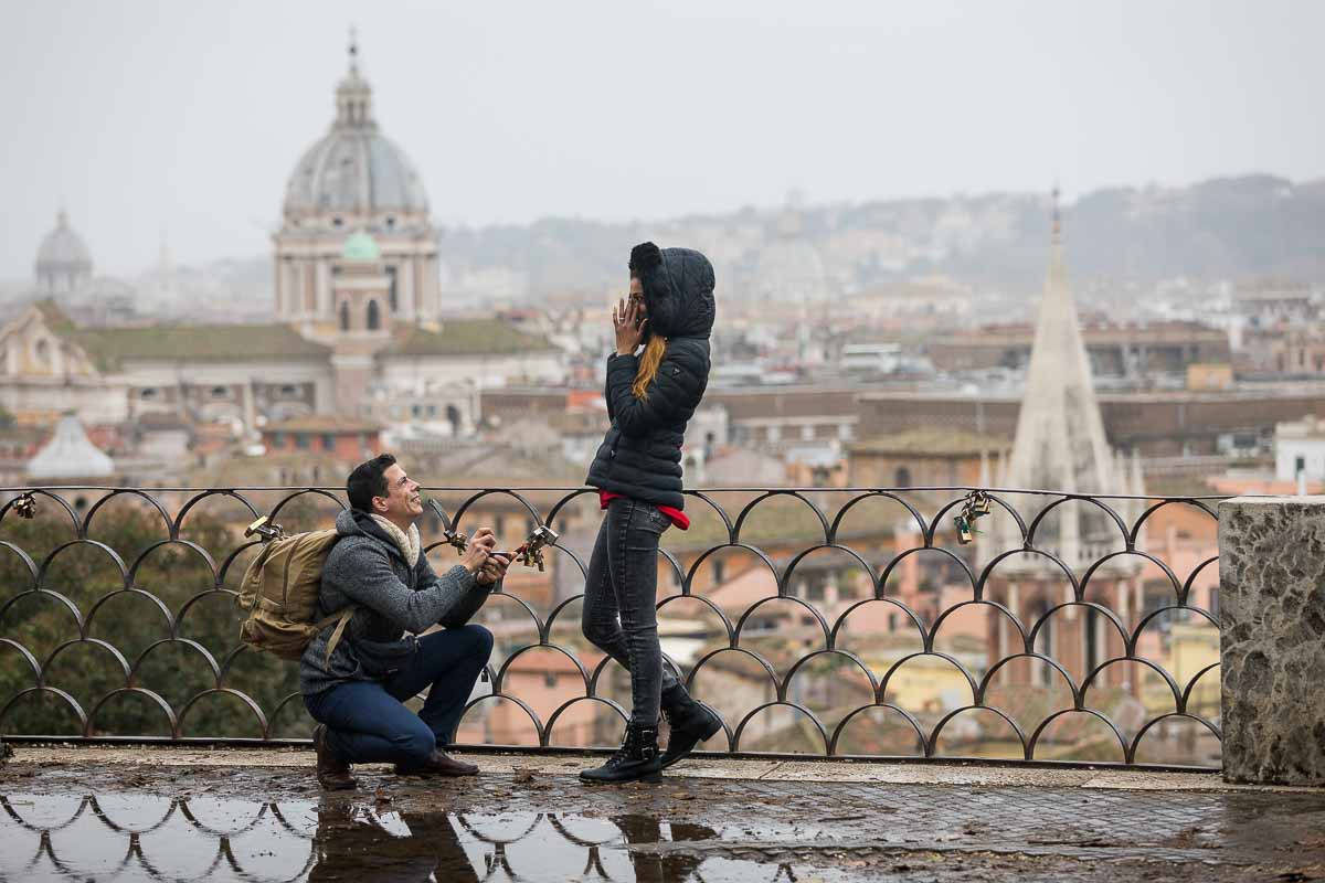 Proposing marriage with the scenic view of the city of Rome in the far background