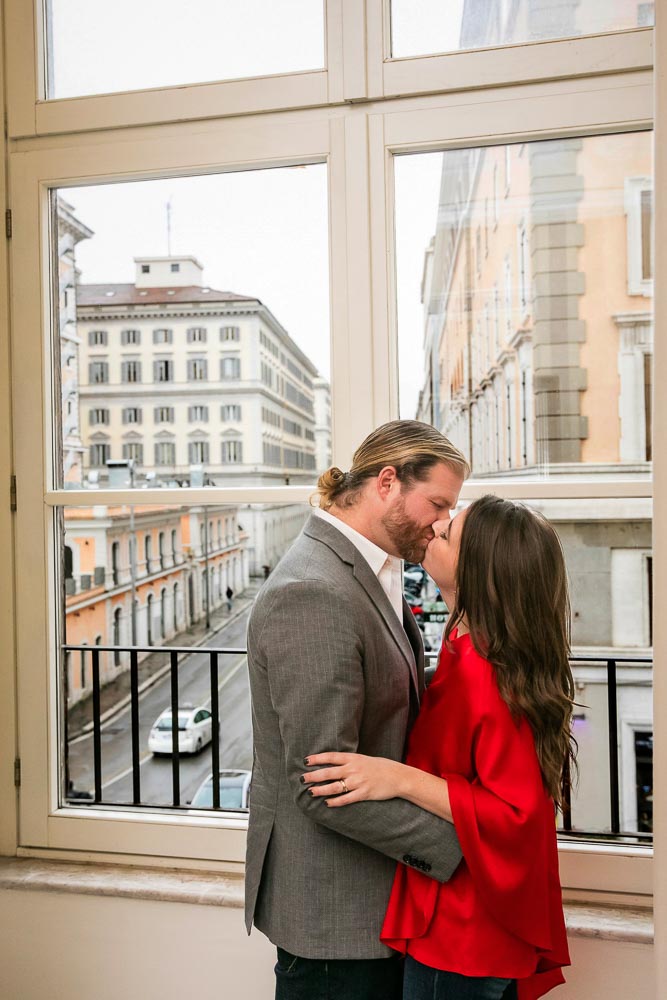 Kissing before the window view over the city of Rome