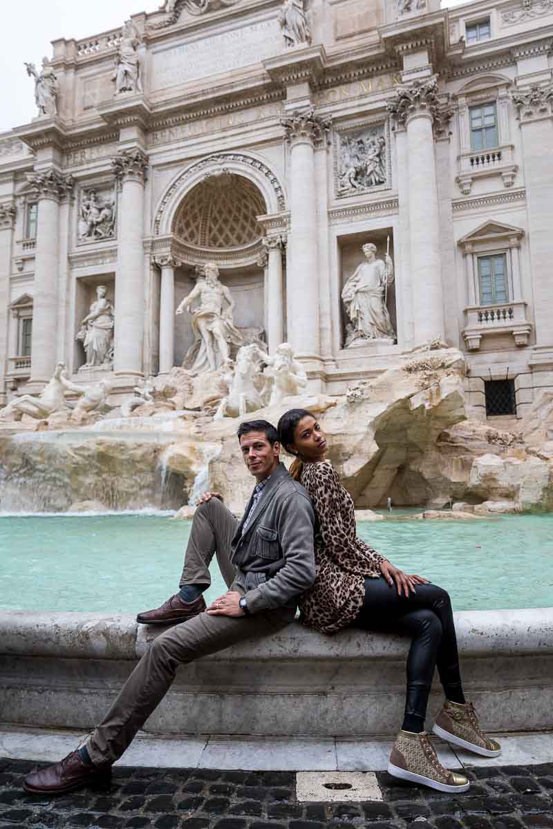 Trevi fountain couple engagement photo shoot while sitting down on the water edge