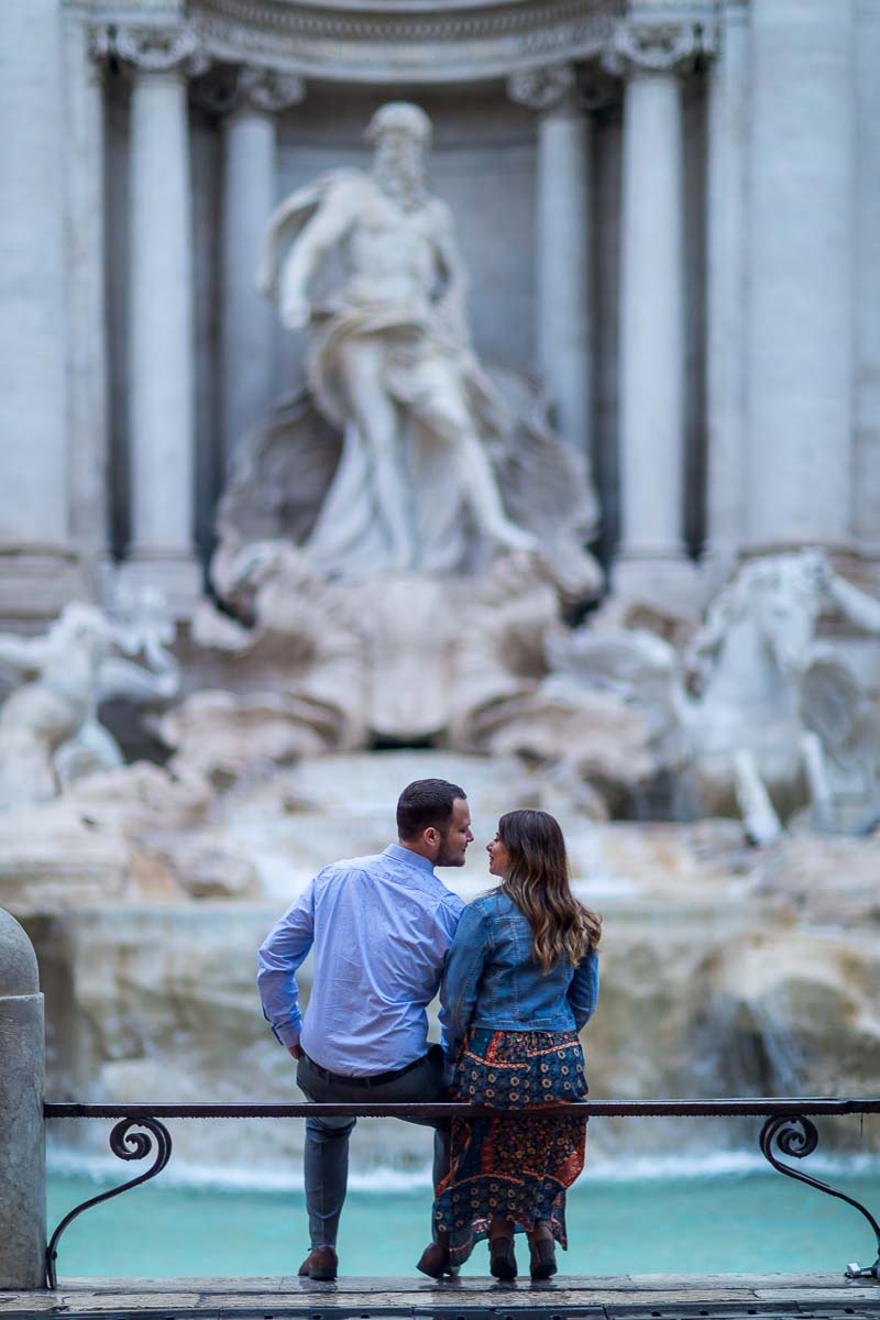 Couple sitting down admiring the spectacular water fountain. Romance in Rome.