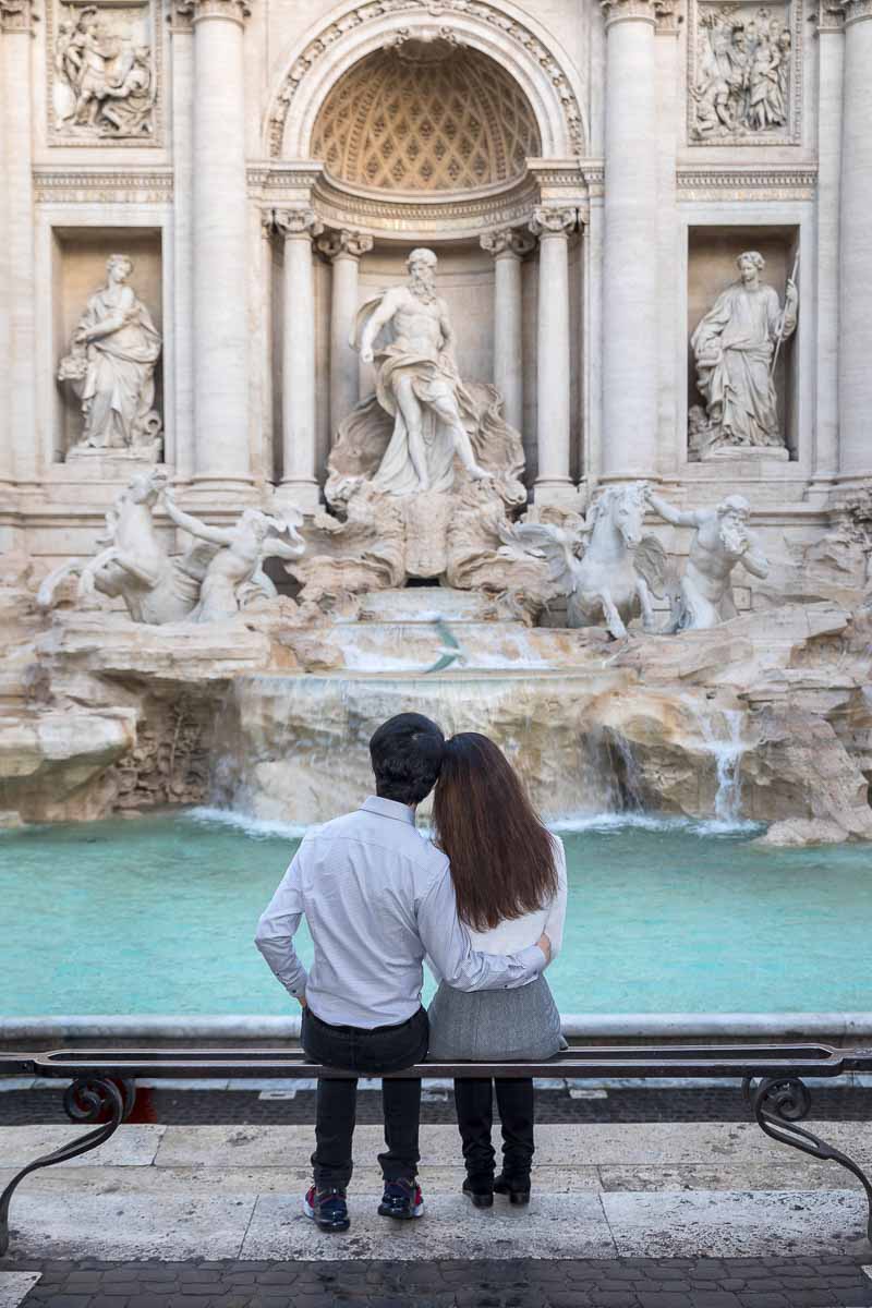 Sitting down romantic photo of being together while admiring Rome's beautiful landmarks like Trevi fountain