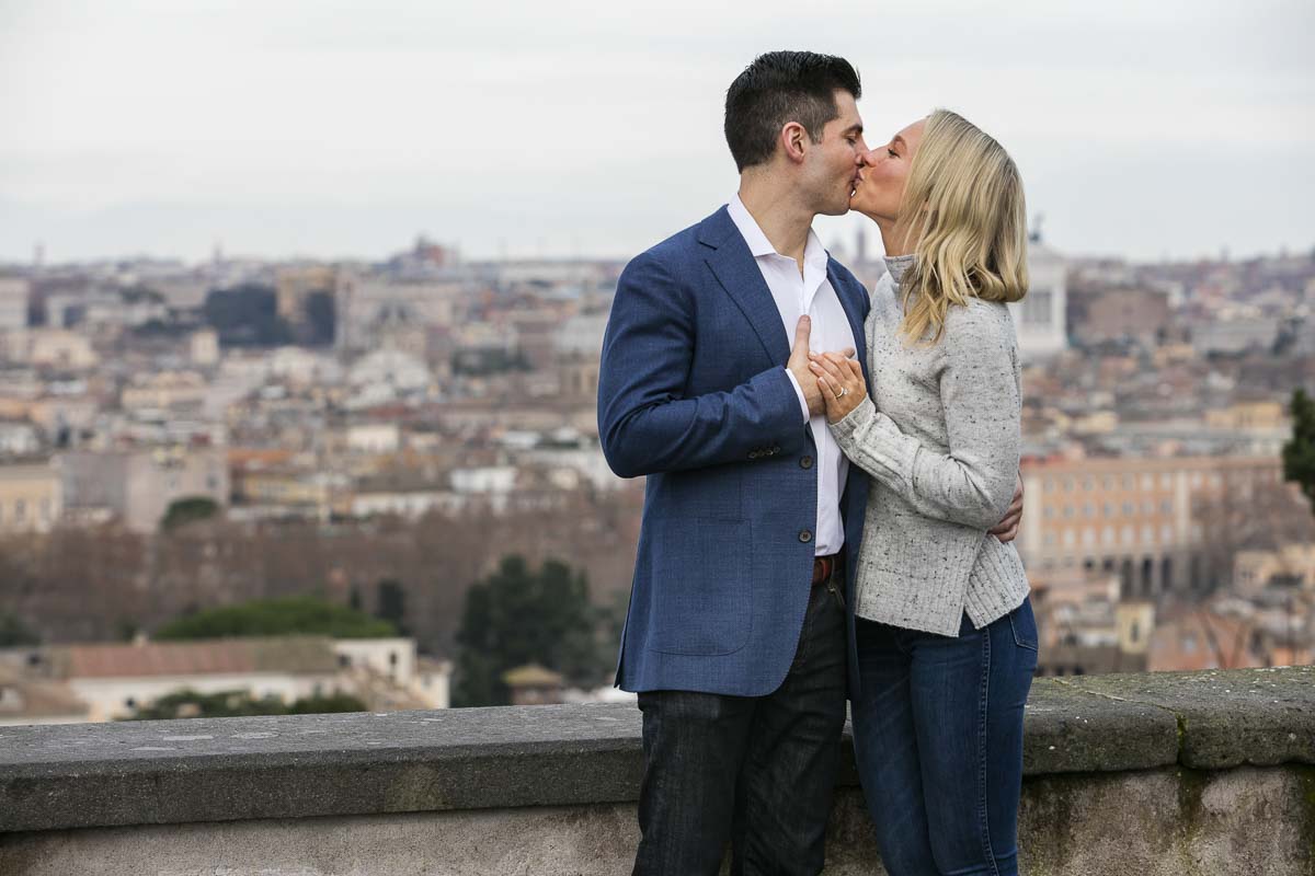 Couple kissing during a photo shoot with the Rome city view in the backdrop