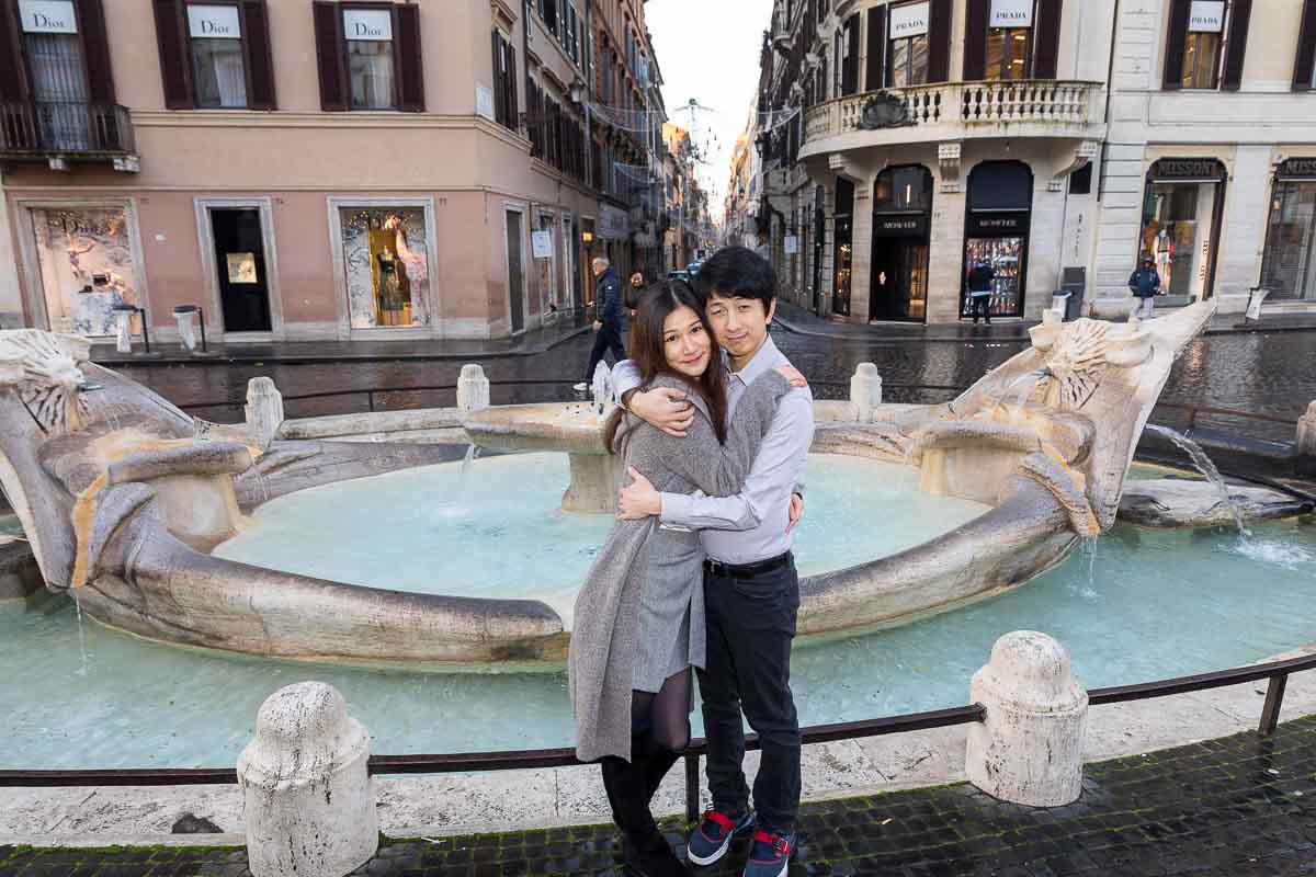 Just engaged posing in front of the Barcaccia water fountain found at the bottom of Piazza di Spagna