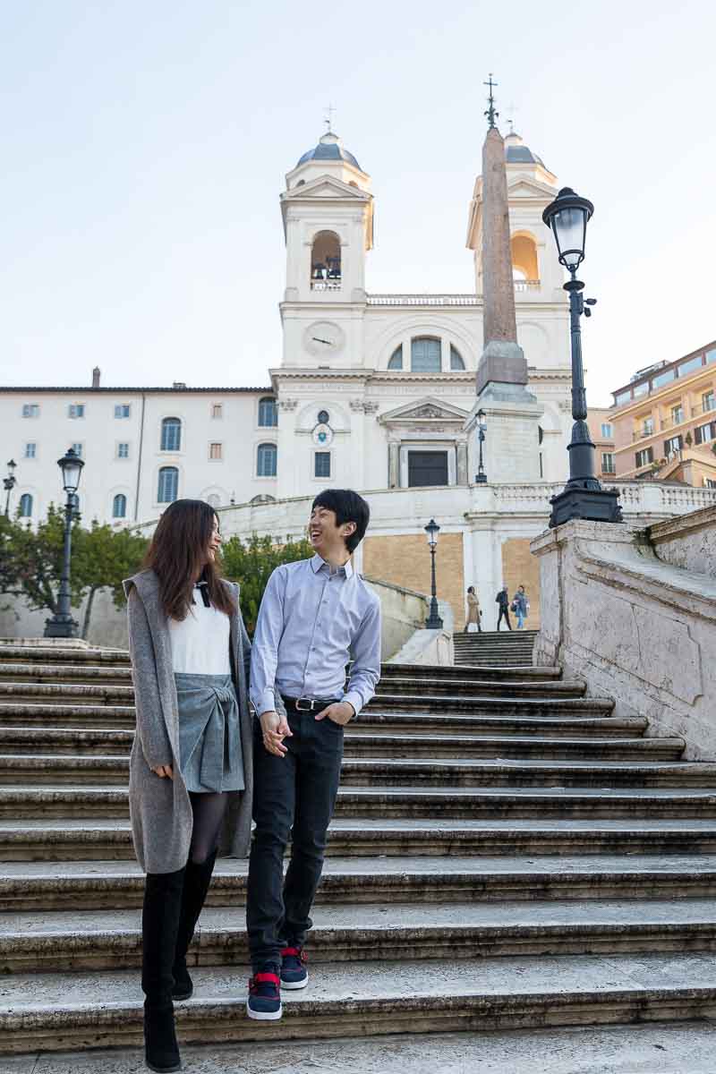 Walking down scalinata di Piazza di Spagna holding hands and enjoying the visit. Engaged Photos in Rome