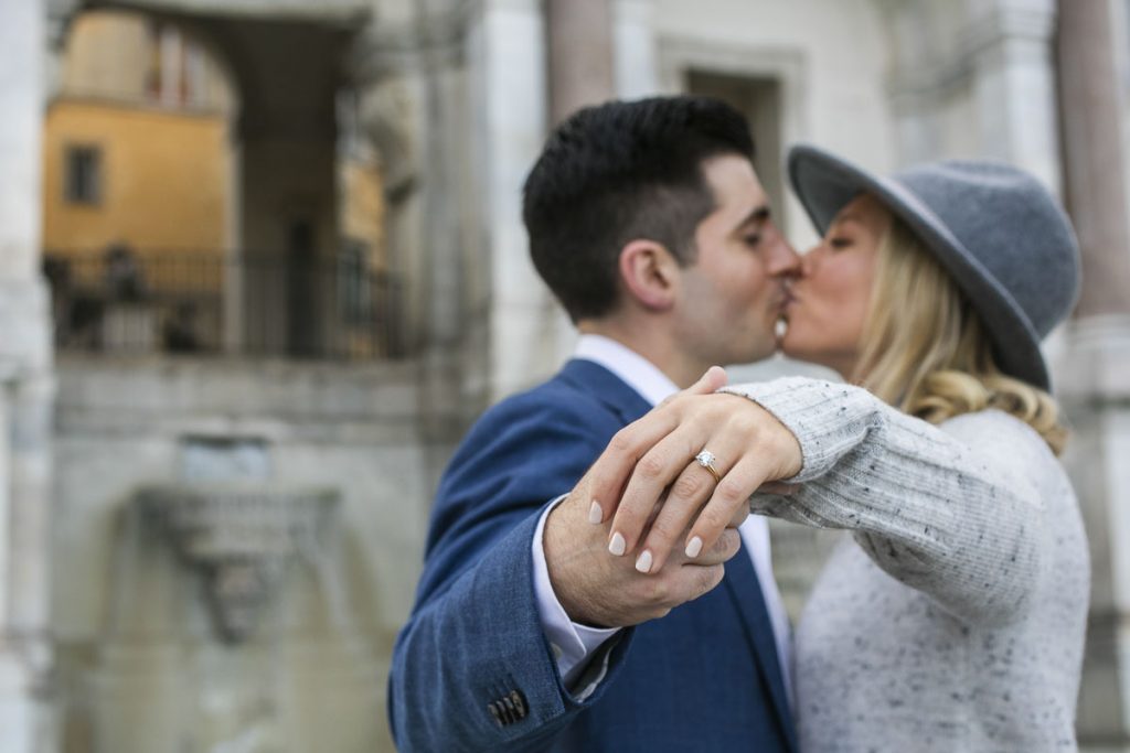 Kissing while showing the engagement ring holding each other hand