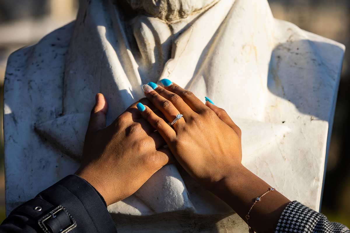 Couple's hands one over another with the engagement ring showing