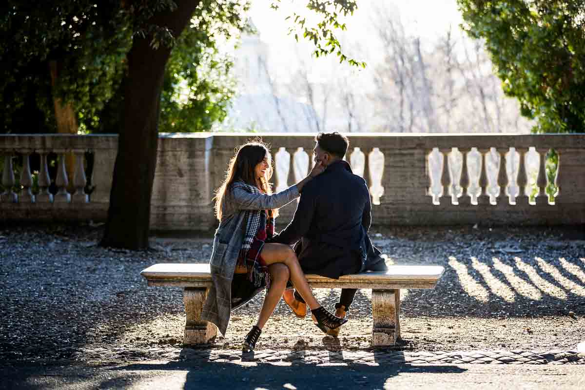 Sitting down portrait of a couple on a marble bench with golden sunsetting light