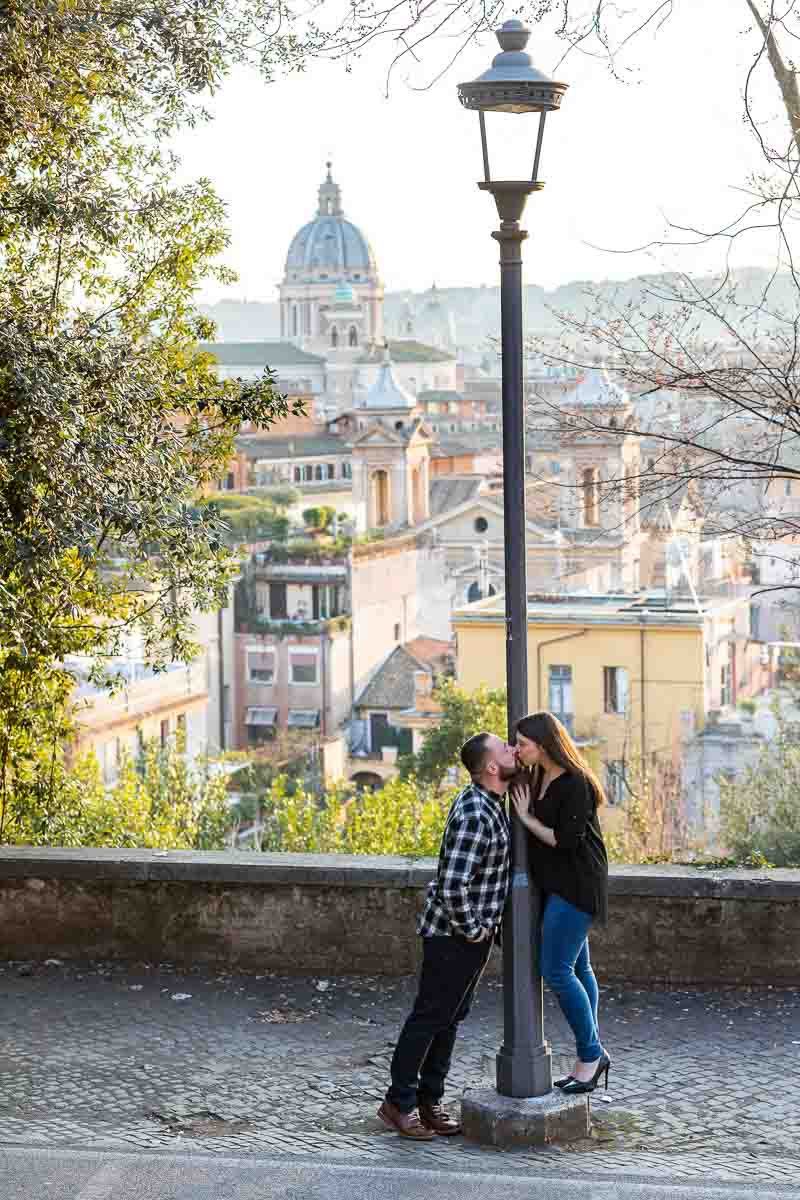 Kissing before the beautiful view over the city of Rome in the far distance