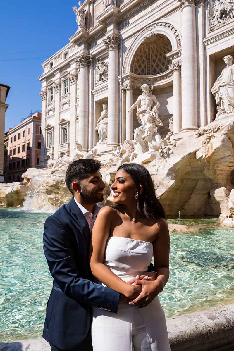 Bride and groom photographed together at the water edge of the magnificent Rome's Trevi fountain