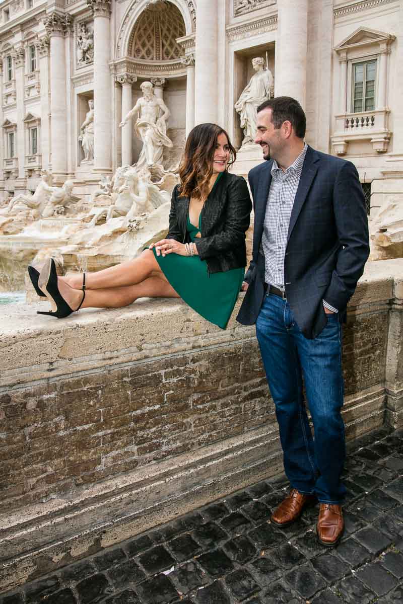 Sitting down pose framing a couple looking at each other in front of Fontana di Trevi