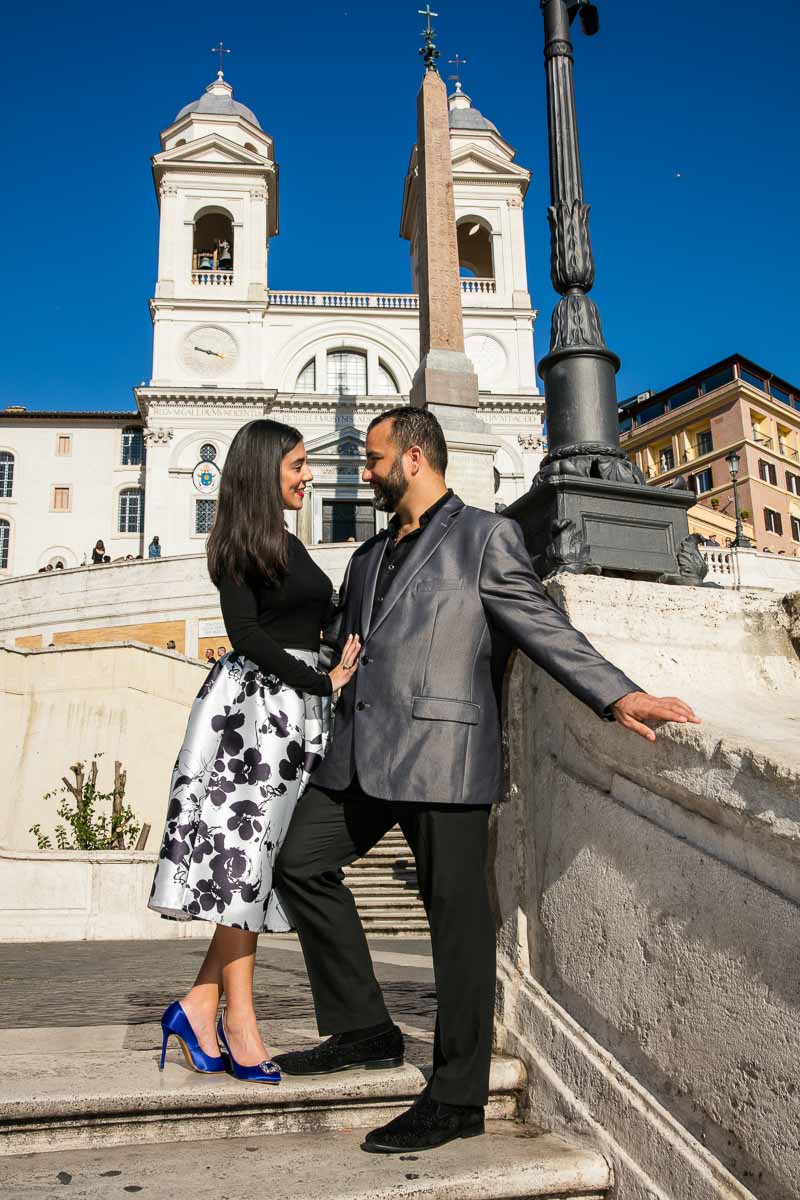 Couple portrait photo underneath church Trinita dei Monti on top of Piazza di Spagna