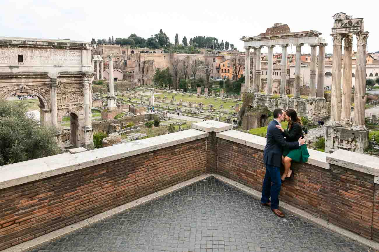 Kissing together before the sweeping view over the ancient roman forum