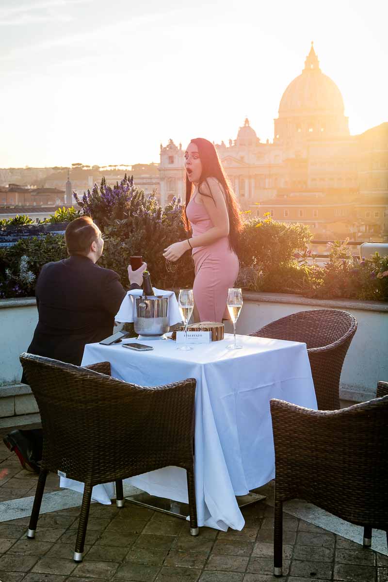 Truly surprised effect during a unique and magical proposal overlooking the city of Rome from an above terrace