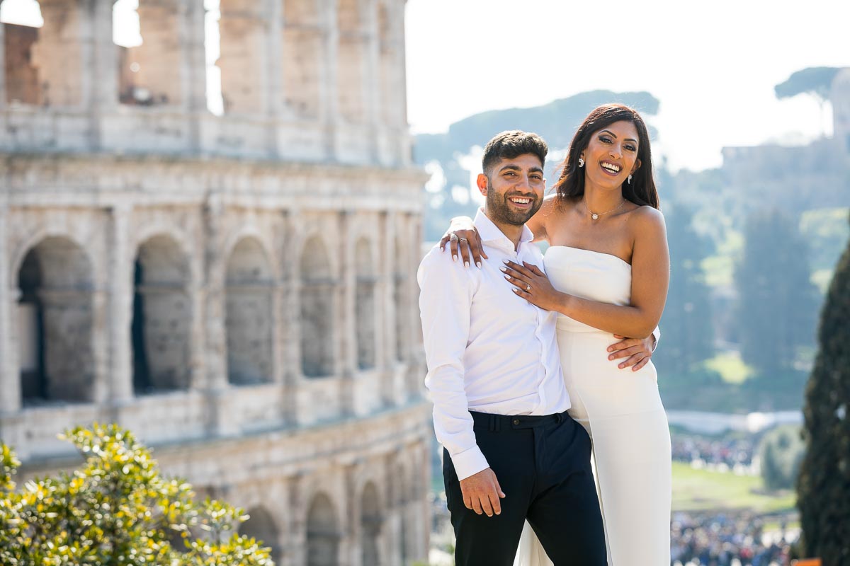Final picture portrait of a couple standing posing and smiling before the Colosseum