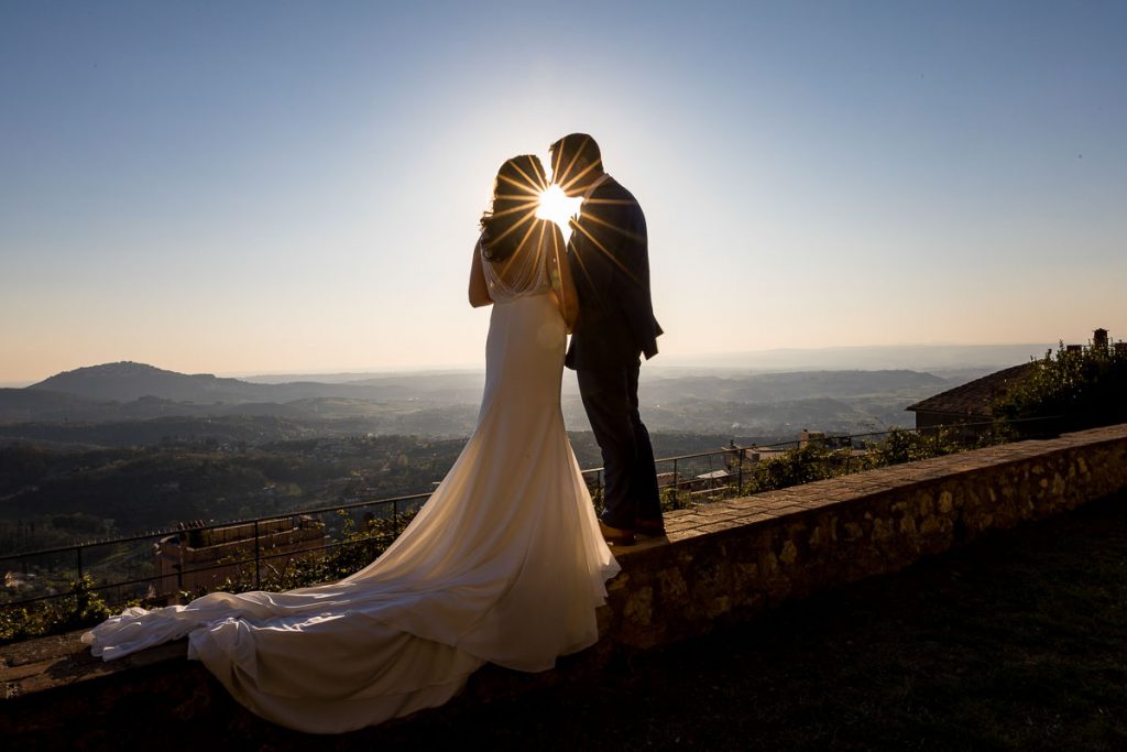 A wedding star in between the newlywed couple overlooking the Italian countryside of Palombara Sabina from Castello Savelli