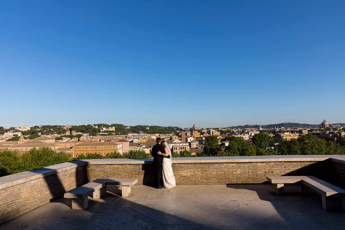 Bride and groom standing on the terrace view of Giardino degli Aranci in Rome Italy observing the panoramic view