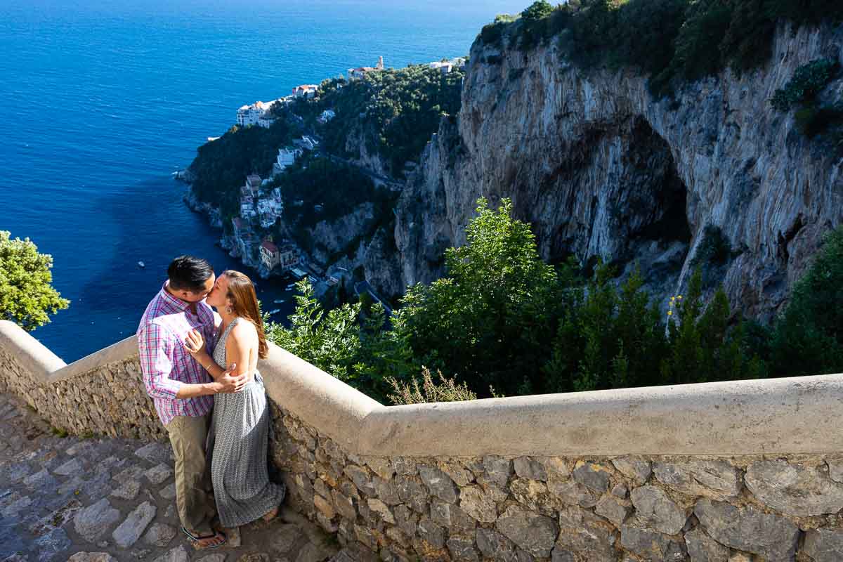 Couple kissing on a staircase before the coast view near the town of Amalfi engagement proposal