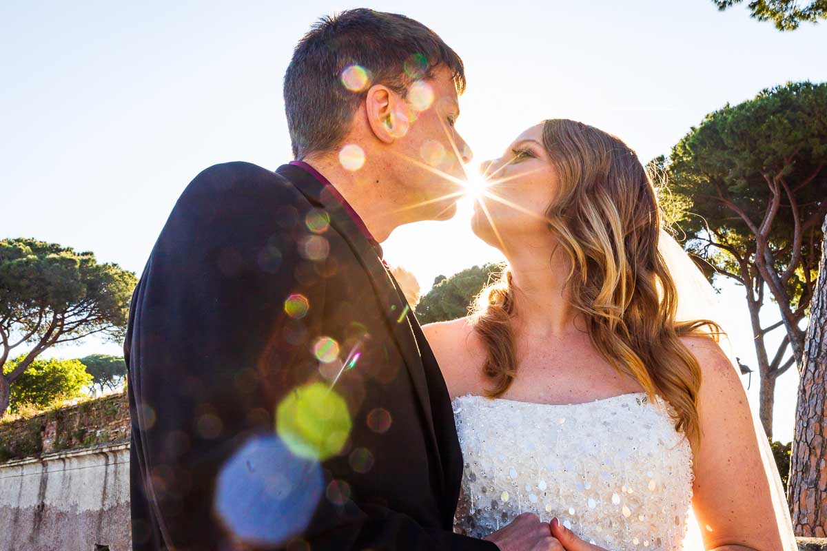 Creative portrait picture playing with the sunlight shining from the sky in between the couple kissing