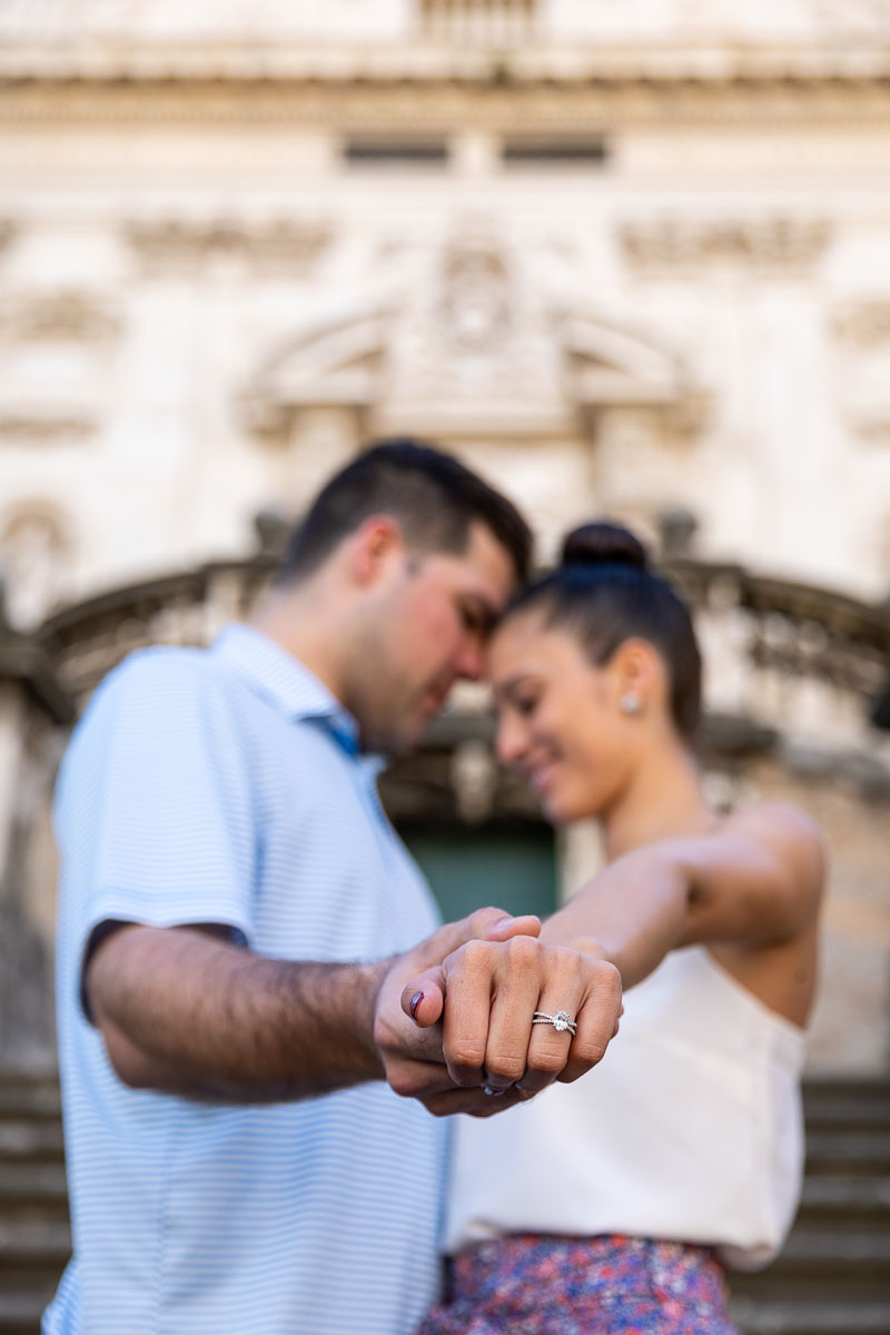 Just engaged holding hands while showing the engagement ring