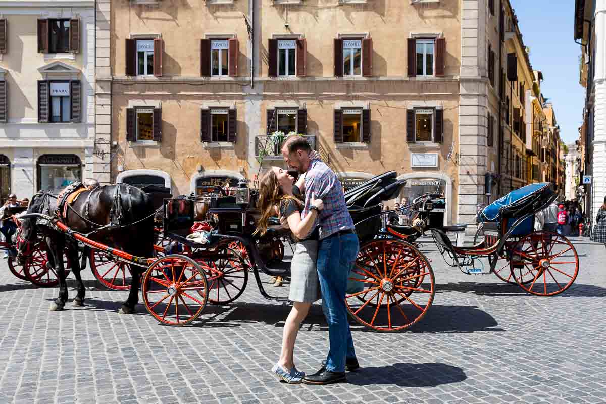 Couple in love in Piazza di Spagna with horse carriages