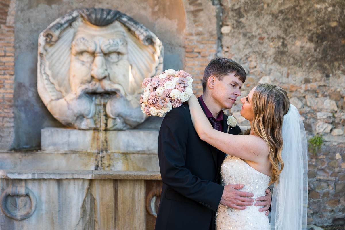 Wedding portrait before the marble statue found at the entrance of the orange garden in Rome