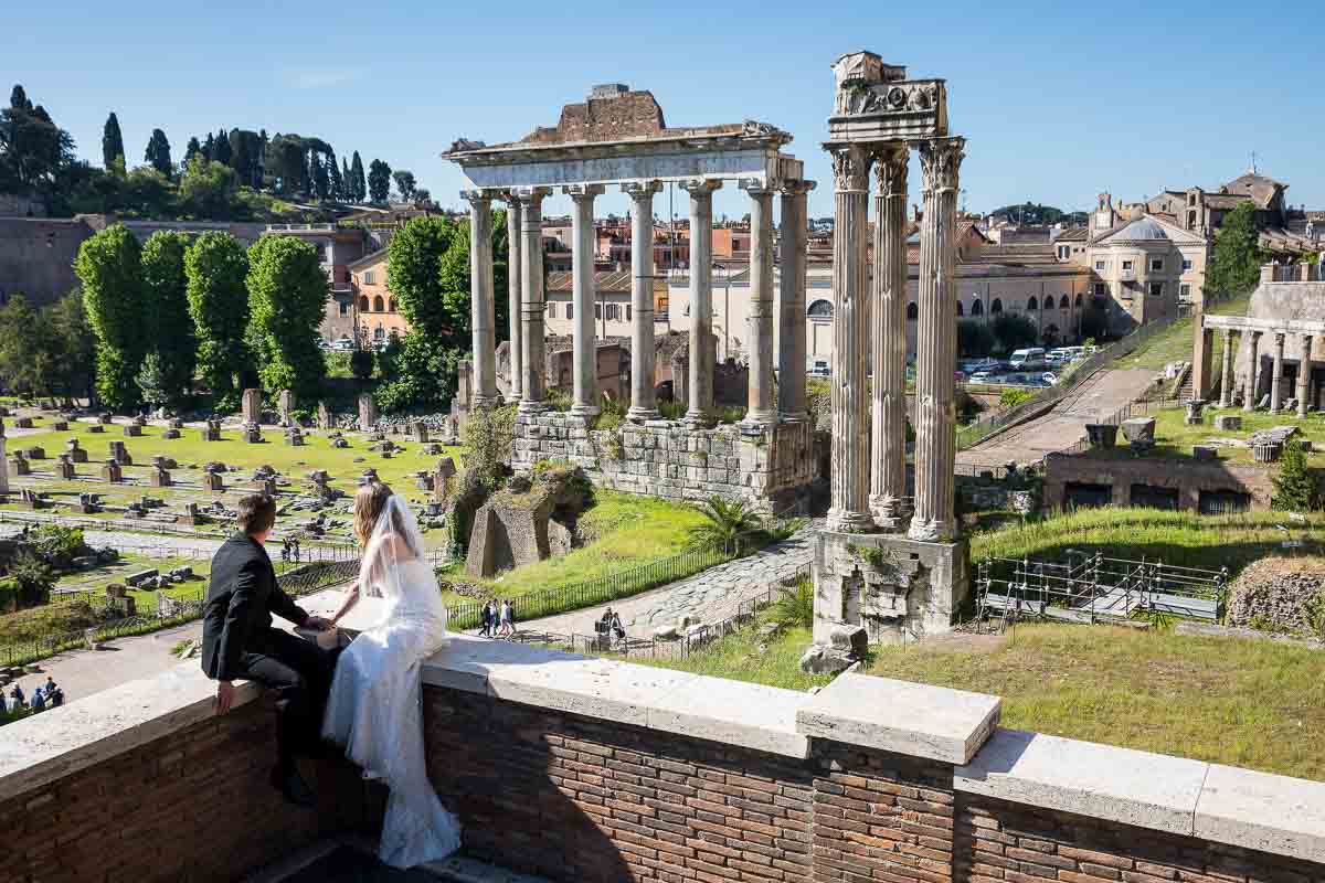 Bride and groom observing the unique and timeless view of the ancient roman ruins found at the imperial forum