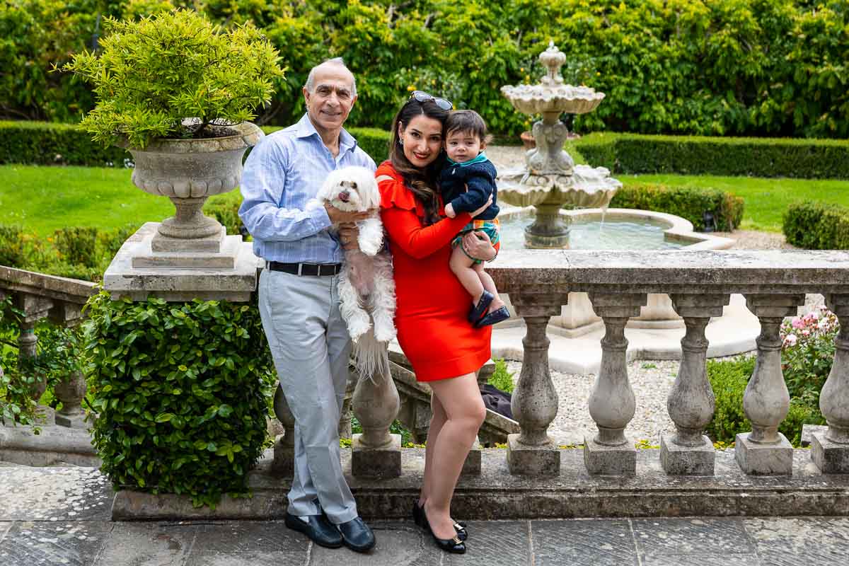 Close up immediate family standing by the balconade overlooking the tuscan scenary