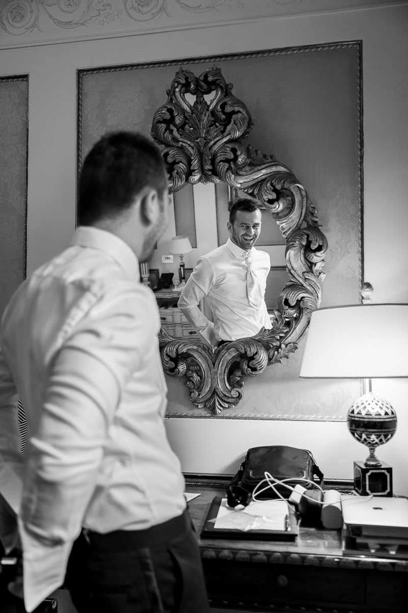 Groom getting ready for marriage in front of the mirror. Image in black and white