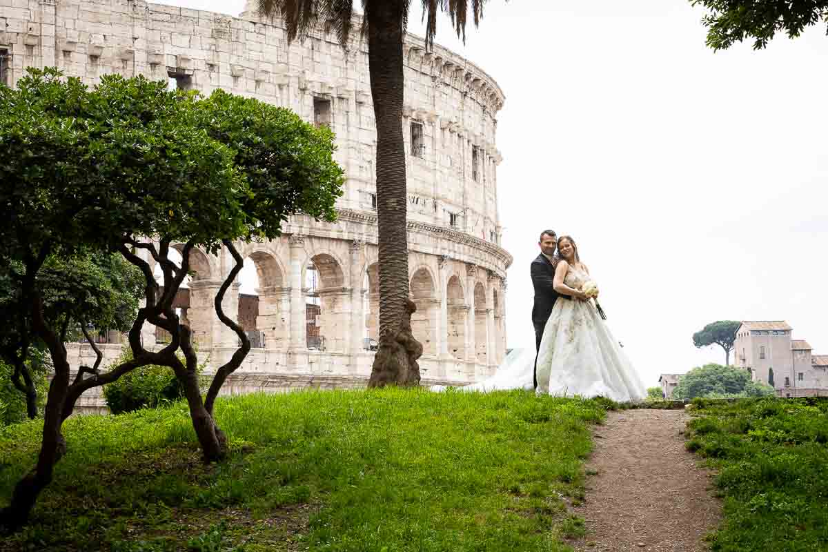 Standing in the far distance in front of the Colosseum Rome Destination Wedding 