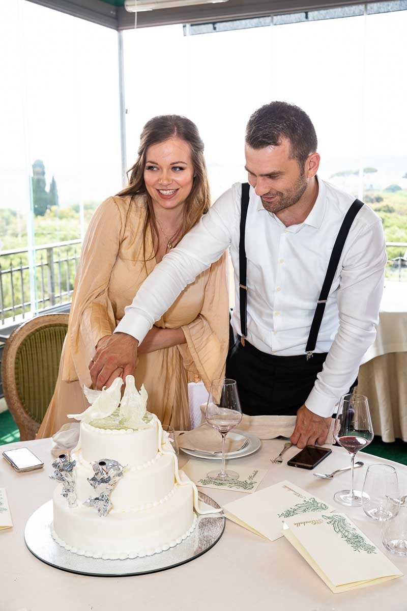 Bride and groom cutting the wedding cake at the end of the day