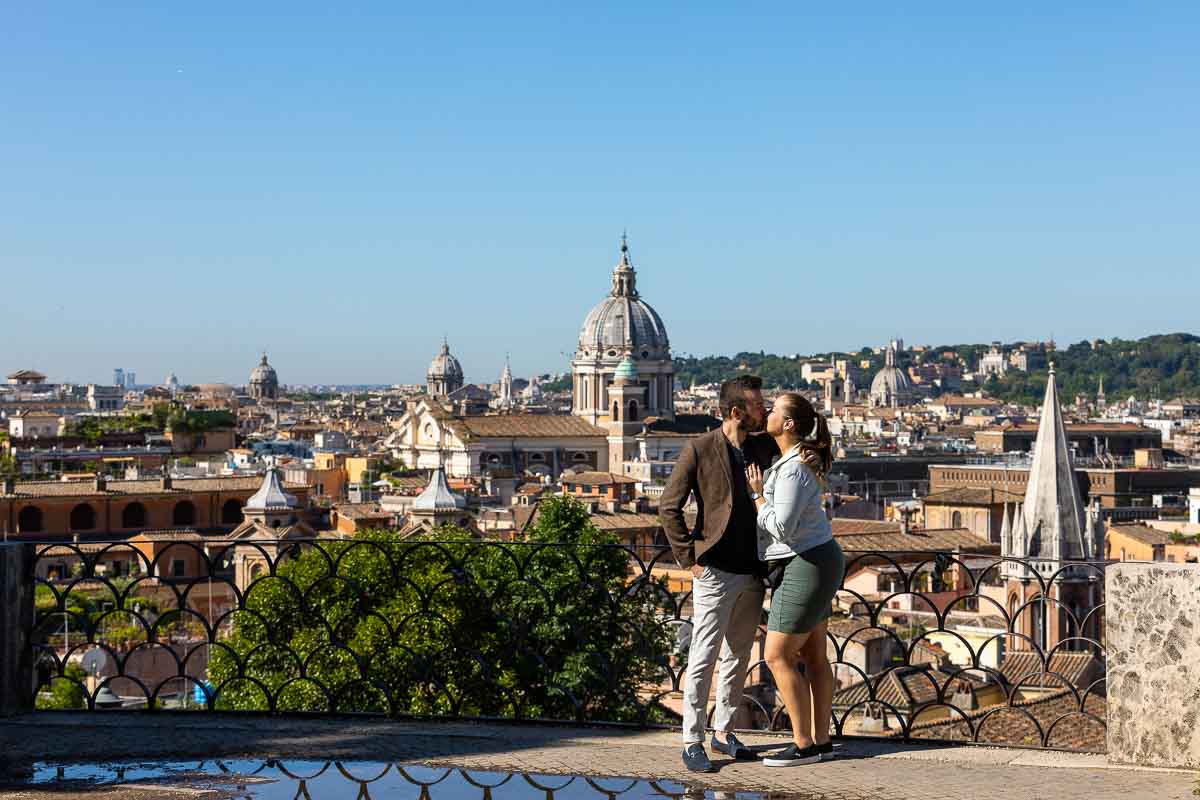 Couple kissing before the roman skyline