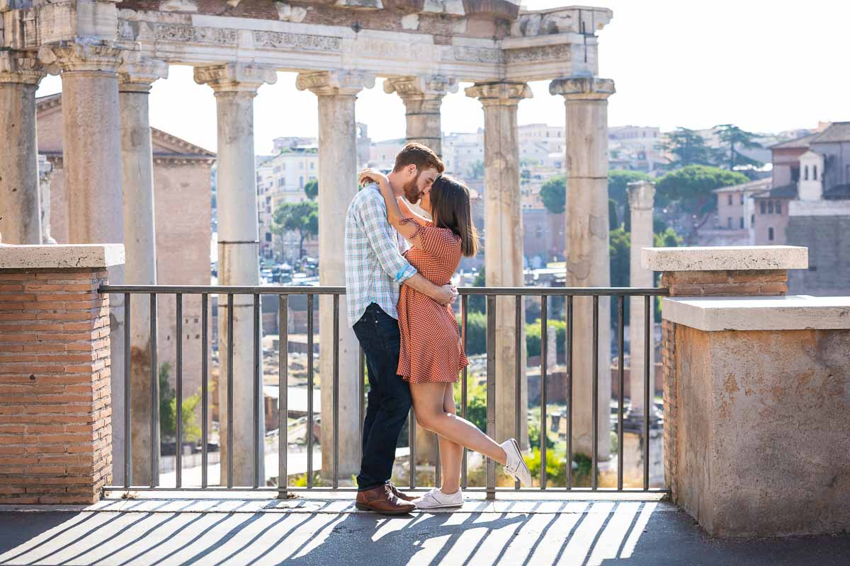 Kissing in ancient Rome. Photo shoot taking place in Piazza del Campidoglio with a unique view over the ancient temple columns