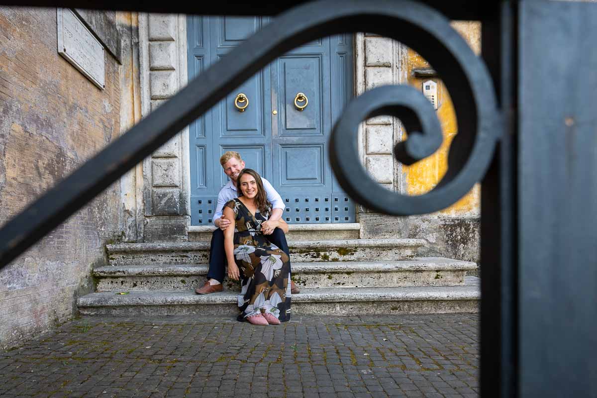 Creative portrait photography couple sitting down before a nice door in Rome