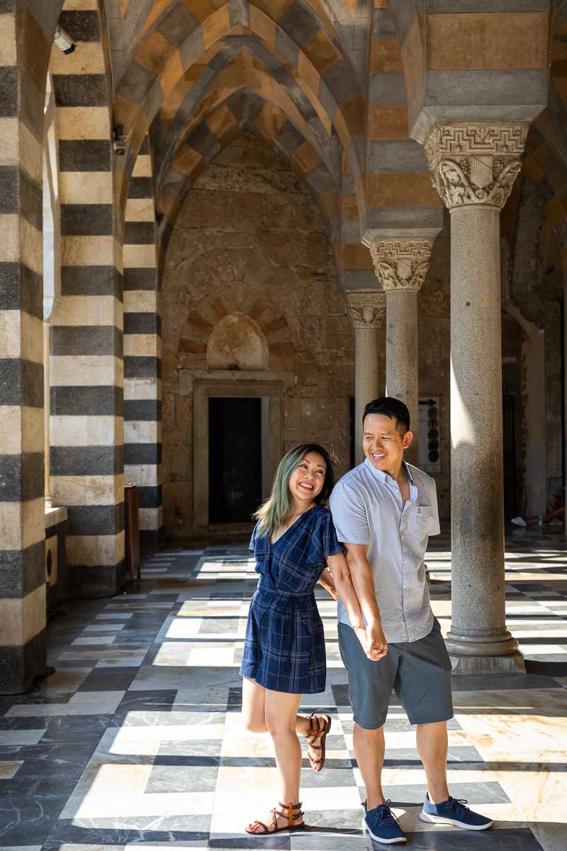 Taking pictures leaning on each other under beautiful architectural columns