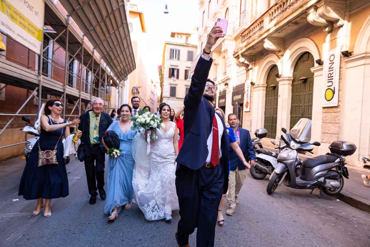 Wedding party walking together towards the Trevi fountain together