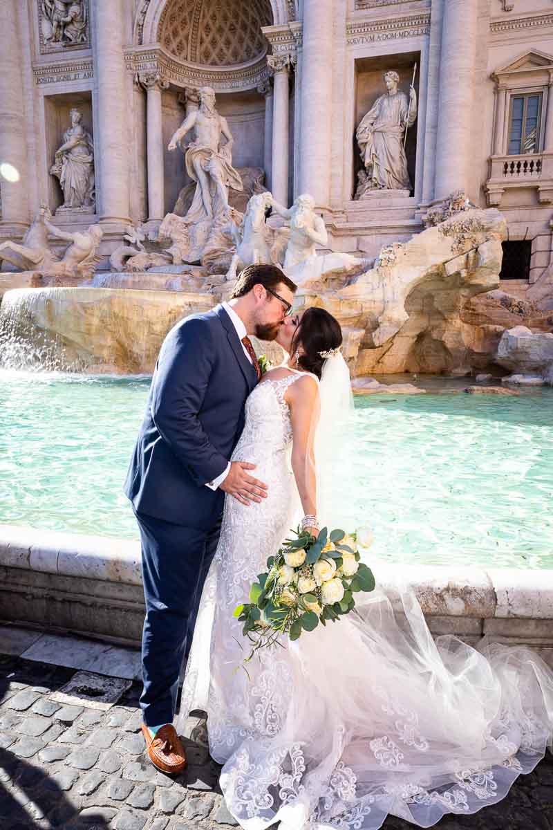 Trevi fountain groom and bride kissing in front of the water fountain