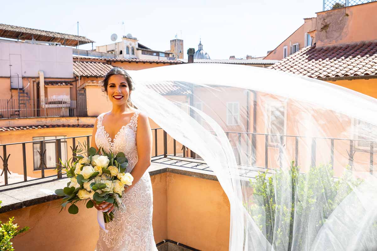 Outside balcony Bride photo with the wedding veil flying up in the air