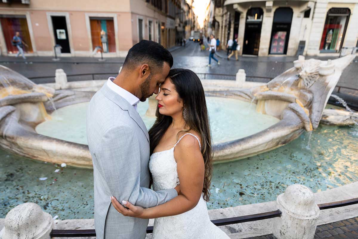 Couple image resting forehead to forehead in front of the barcaccia water fountain