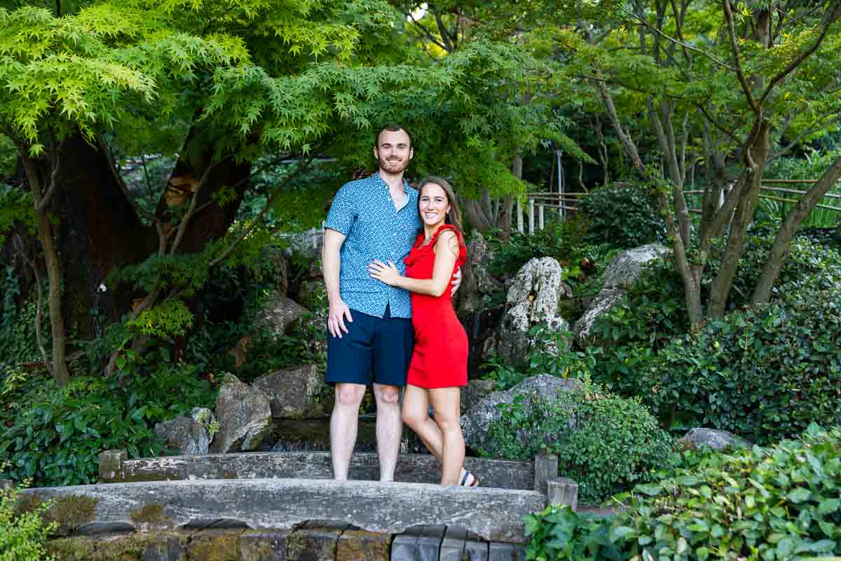 Couple portrait picture posed on the wooden bridge of the Japanese garden