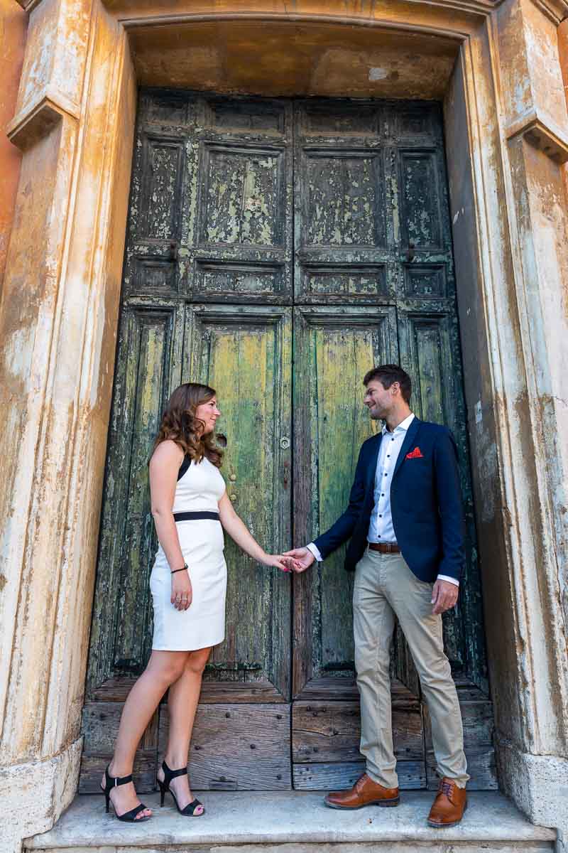 Holding hands in front of an old green church doorway