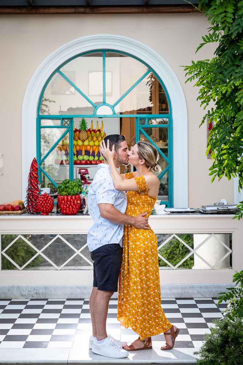 Kissing photo standing and posing before a colorful bar