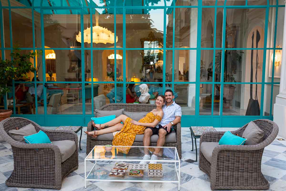 Sitting down on an outdoor couch leaning on each other during a post engagement photo session